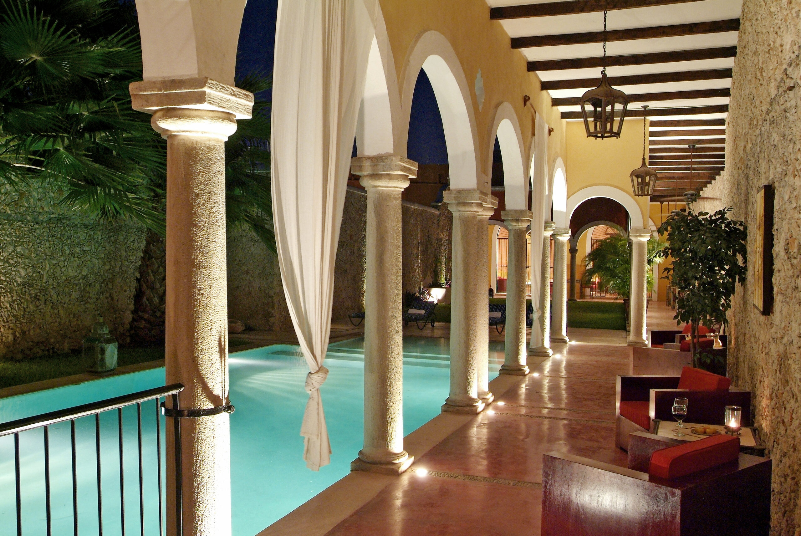 Alberca y arcos de noche, Hotel Hacienda Mérida